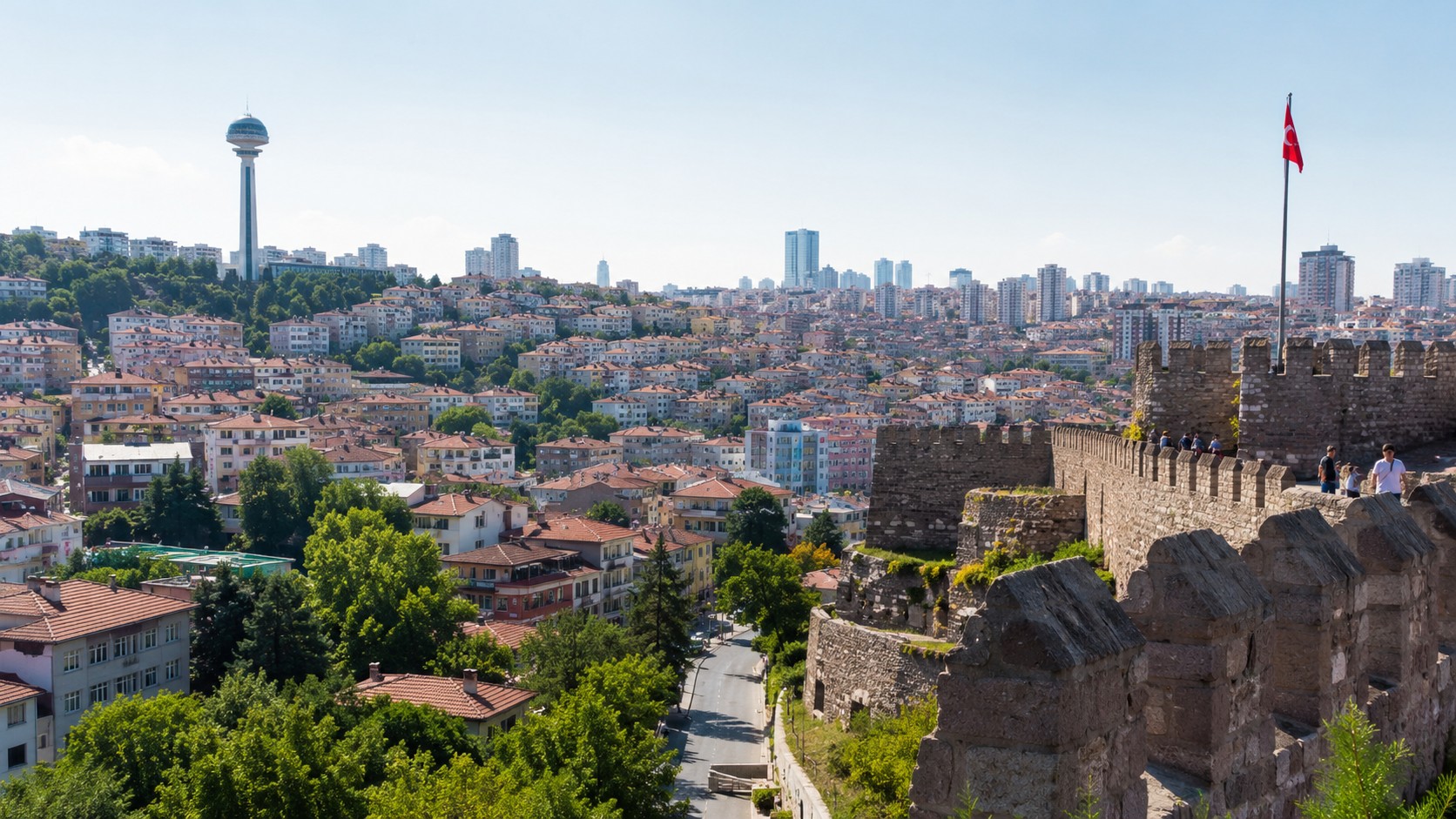 Vue panoramique ensoleillée d’Ankara avec le château d’Ankara au premier plan, la tour Atakule à gauche, le drapeau turc et la skyline urbaine en arrière-plan, photo professionnelle réaliste au format 16/9.