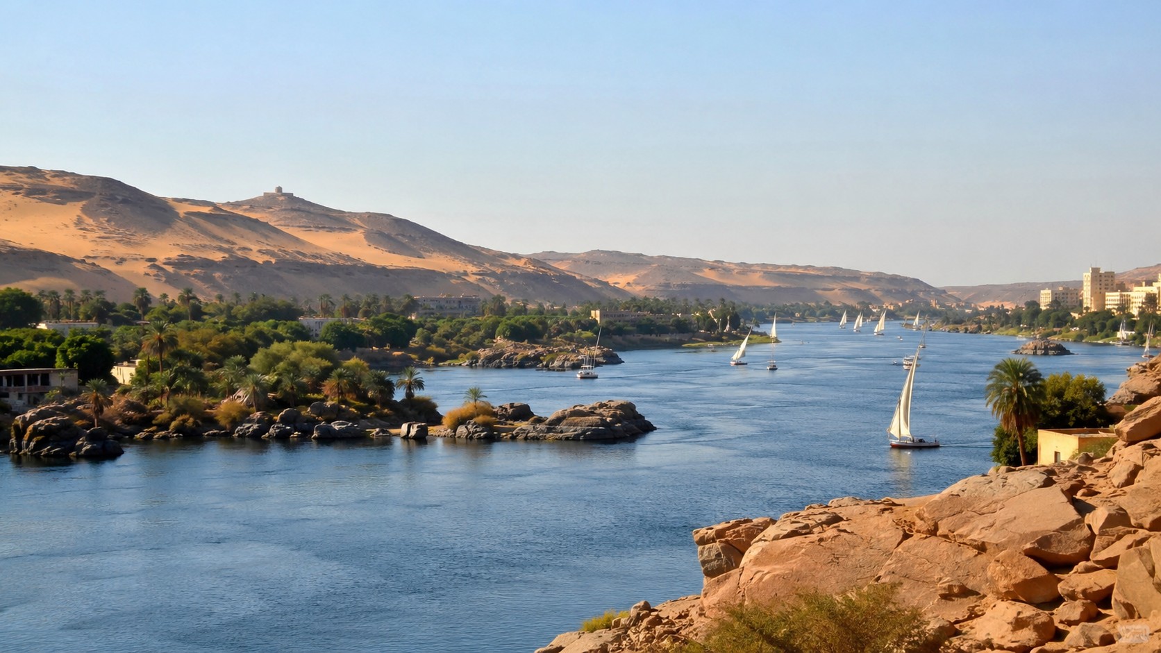 Photo professionnelle ultra réaliste du Nil en Égypte avec fleuve bleu, voiliers traditionnels, palmiers, rochers, dunes dorées et ciel ensoleillé, format 16/9.