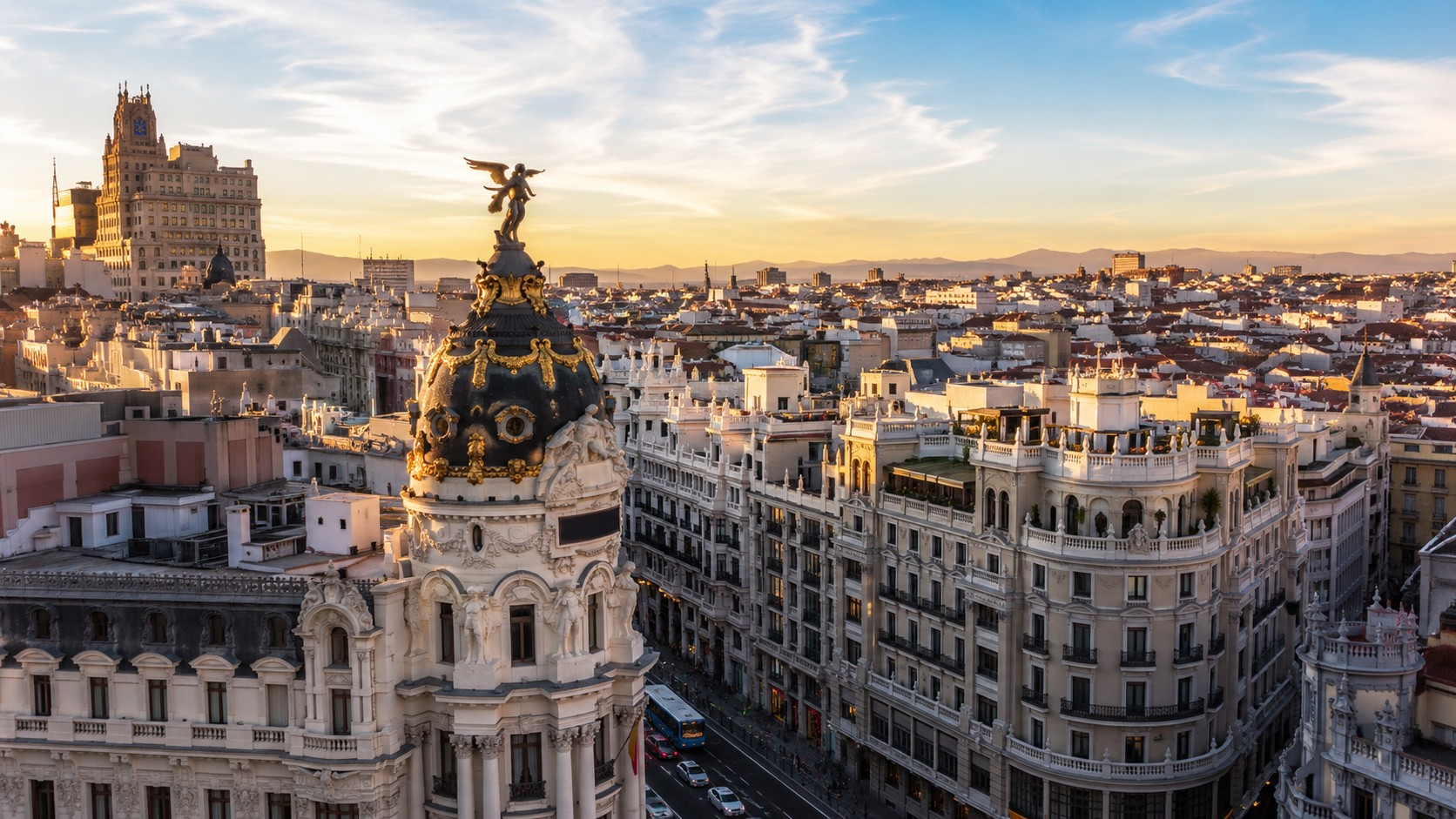 Madrid capitale de l’Espagne, vue urbaine ensoleillée sur la Gran Vía avec architecture historique, coupoles, immeubles anciens et ciel dégagé, 2026, format 16/9