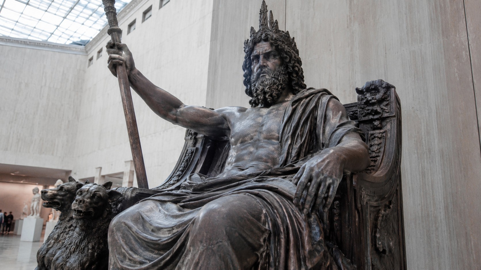 Photographie réaliste d’Hadès, dieu des Enfers dans la mythologie grecque, représenté sous la forme d’une imposante statue assise sur un trône décoré de Cerbère, le chien à trois têtes gardien du royaume des morts. Cliché de style documentaire pris avec un Panasonic GH4 dans un grand musée, mettant en valeur les détails de la sculpture, la barbe du dieu et son sceptre royal.